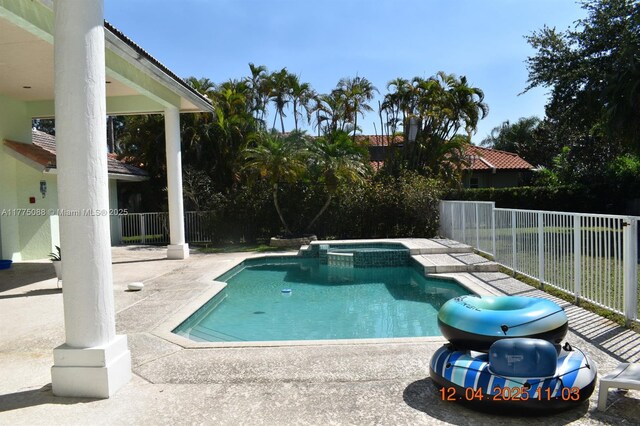 12044 NW 9th Pl, Coral Springs, FL 33071 - view of swimming pool featuring a fenced backyard, a pool with connected hot tub, and a patio area