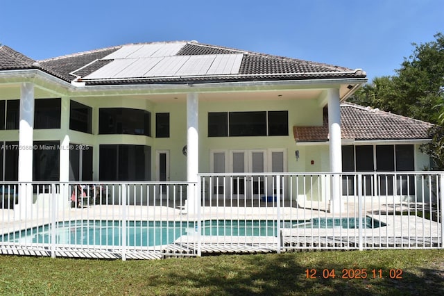 12044 NW 9th Pl, Coral Springs, FL 33071 - back of property with an outdoor pool, a tiled roof, a patio area, and stucco siding