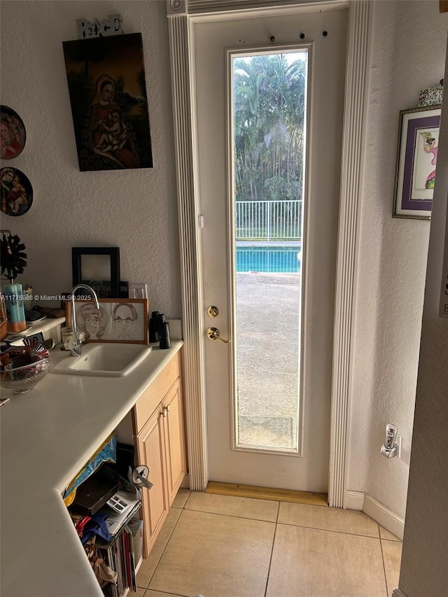 12044 NW 9th Pl, Coral Springs, FL 33071 - doorway to outside featuring a sink, light tile patterned flooring, and a textured wall