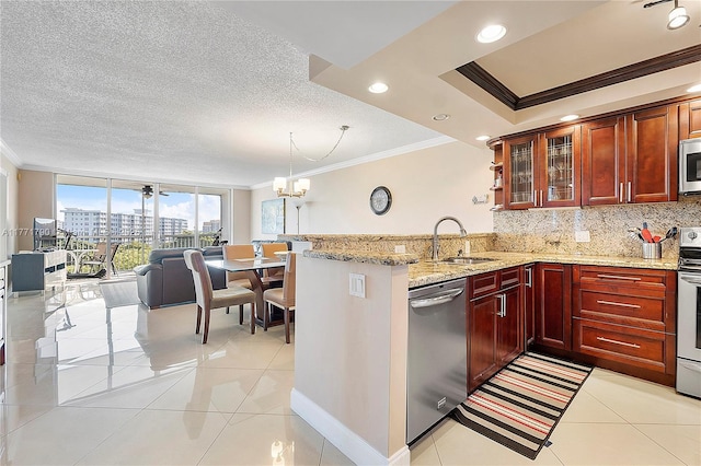 2940 N Course Dr Unit 712, Pompano Beach, FL 33069 - kitchen with appliances with stainless steel finishes, ornamental molding, a sink, a peninsula, and tasteful backsplash