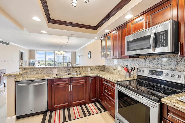 2940 N Course Dr Unit 712, Pompano Beach, FL 33069 - kitchen featuring appliances with stainless steel finishes, a sink, ornamental molding, a peninsula, and a raised ceiling