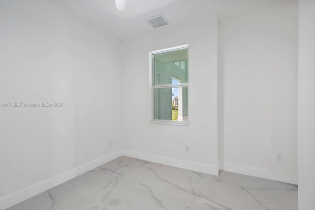 empty room featuring marble finish floor, baseboards, and visible vents