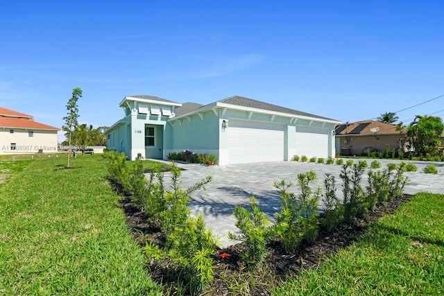 view of front of property with stucco siding, a front yard, driveway, and a garage
