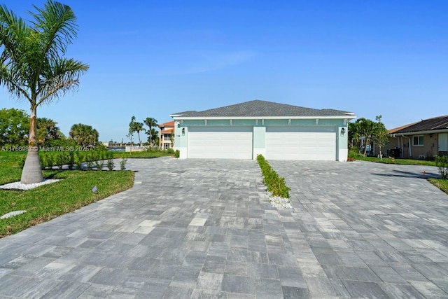exterior space with decorative driveway, a garage, and stucco siding