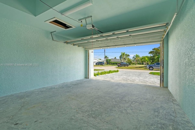 garage with a textured wall and a garage door opener