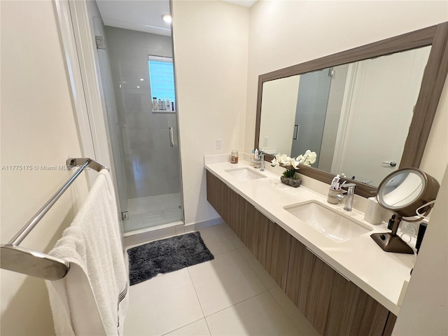 full bath featuring a stall shower, double vanity, tile patterned flooring, and a sink