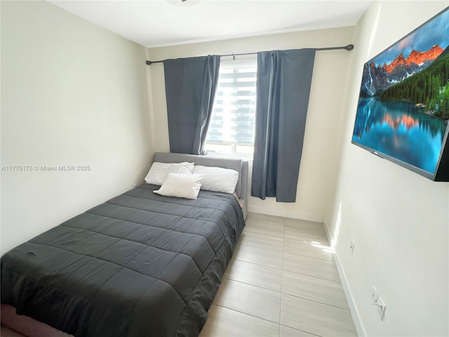 tiled bedroom featuring baseboards