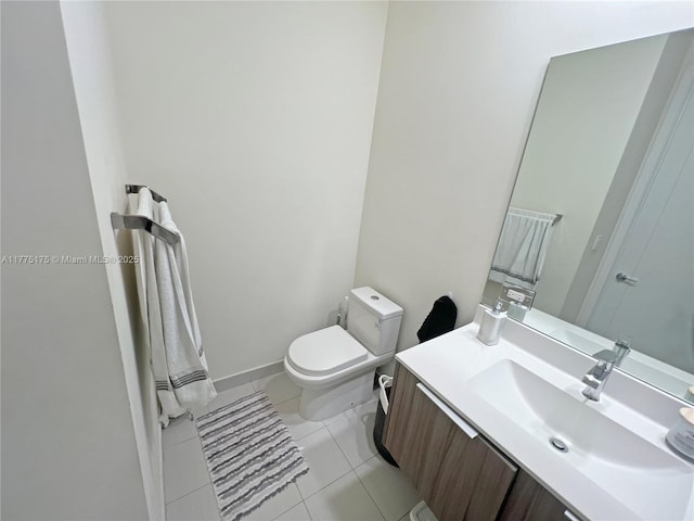 bathroom featuring toilet, vanity, baseboards, and tile patterned flooring