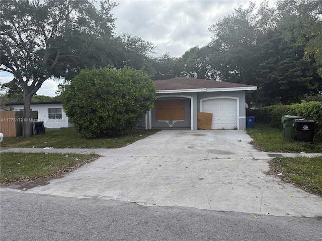 single story home featuring stucco siding, driveway, a front yard, and a garage