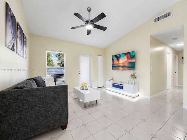 living area with visible vents, baseboards, a ceiling fan, lofted ceiling, and light tile patterned floors