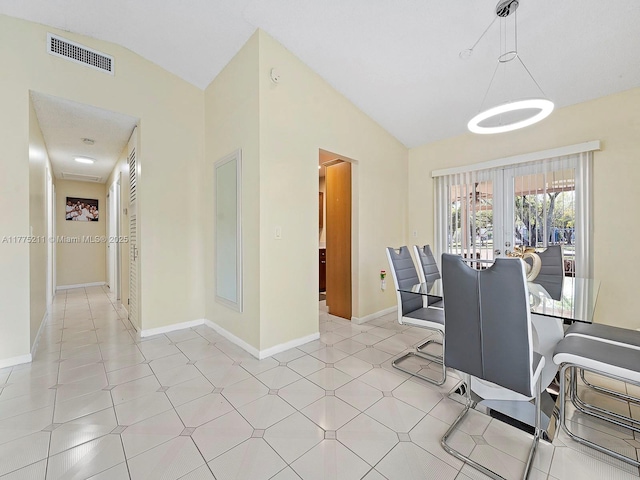 dining area with light tile patterned floors, baseboards, lofted ceiling, and visible vents
