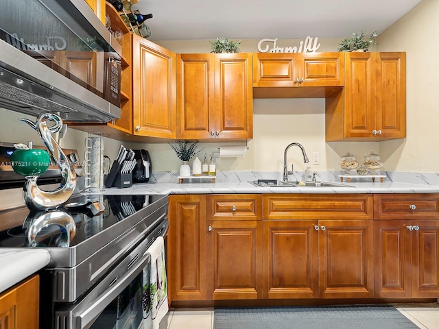 kitchen with appliances with stainless steel finishes, brown cabinets, and a sink