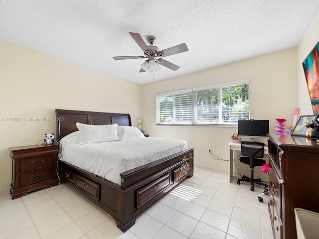 bedroom with light tile patterned flooring, a textured ceiling, baseboards, and a ceiling fan