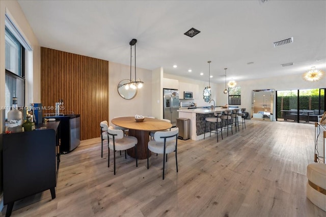 dining area featuring light wood finished floors, visible vents, a notable chandelier, and recessed lighting