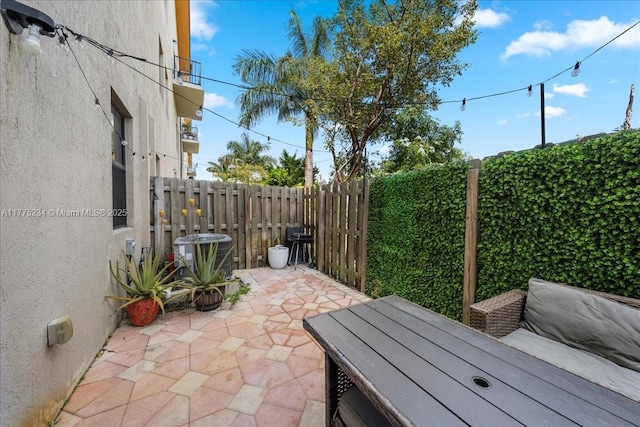 view of patio featuring a fenced backyard, area for grilling, and central AC unit