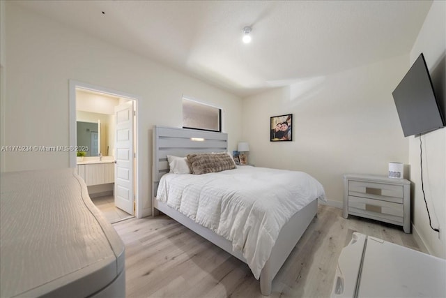 bedroom with baseboards, ensuite bathroom, and light wood-type flooring