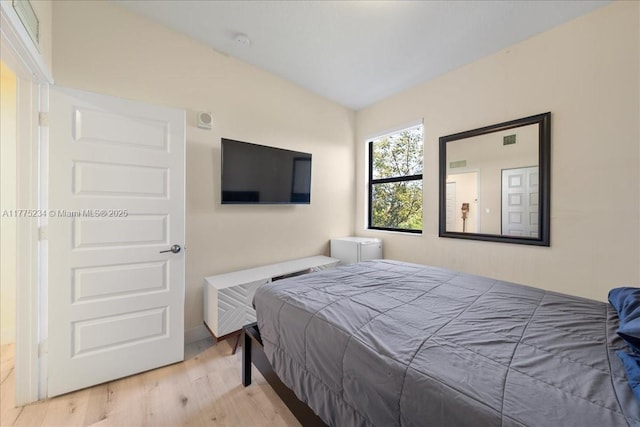bedroom featuring lofted ceiling and wood finished floors
