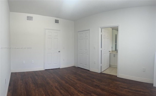 unfurnished bedroom featuring baseboards, visible vents, and wood finished floors