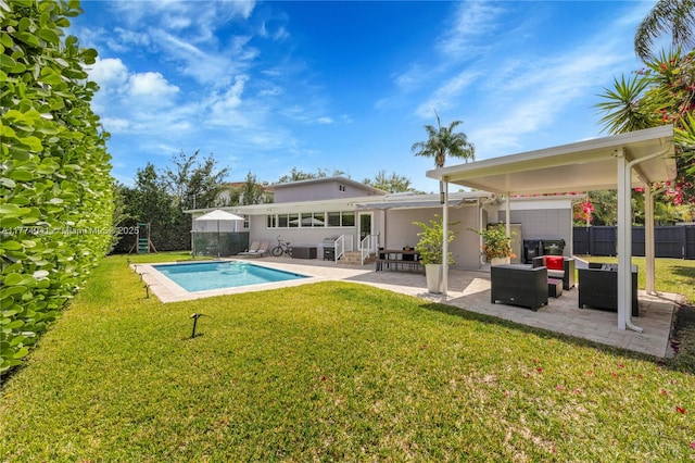 back of property with fence, a patio, a fenced in pool, stucco siding, and a yard