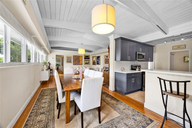 dining room featuring baseboards, beamed ceiling, wood ceiling, and light wood-type flooring