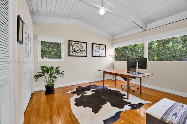 home office featuring a wealth of natural light, vaulted ceiling with beams, baseboards, and wood finished floors