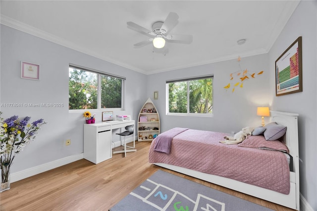 bedroom with baseboards, crown molding, light wood-style flooring, and ceiling fan