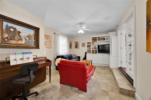 living room featuring baseboards and a ceiling fan