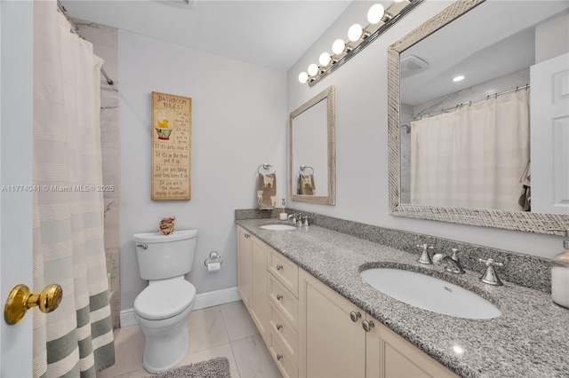 bathroom featuring tile patterned flooring, toilet, baseboards, a sink, and double vanity