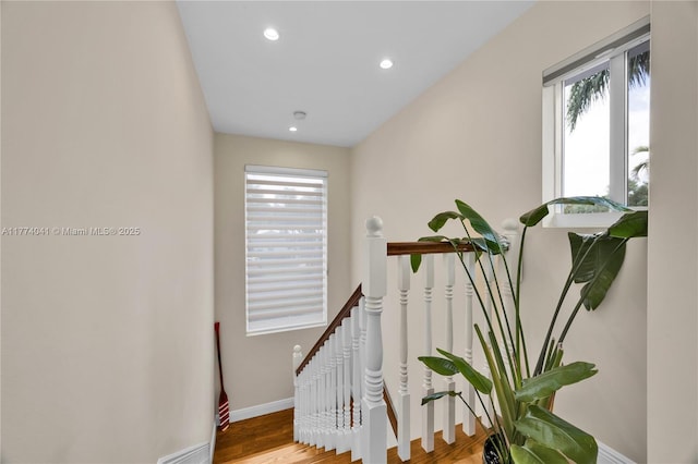 staircase featuring baseboards, wood finished floors, and recessed lighting
