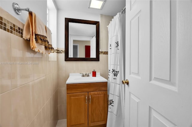 full bath with vanity and tile walls