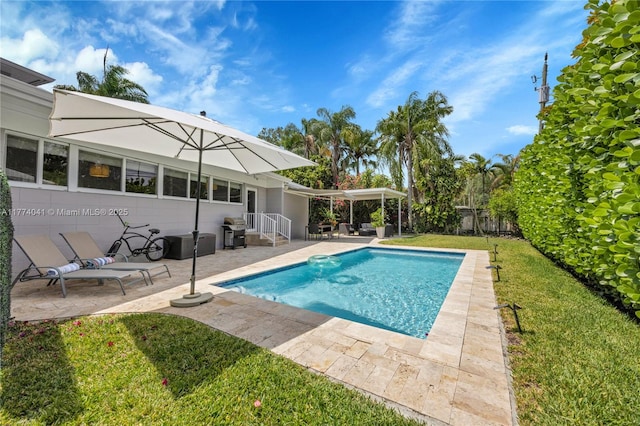 outdoor pool featuring a lawn, grilling area, a patio area, and fence private yard