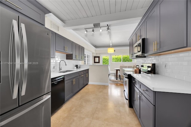 kitchen featuring decorative backsplash, light countertops, appliances with stainless steel finishes, a sink, and light tile patterned floors