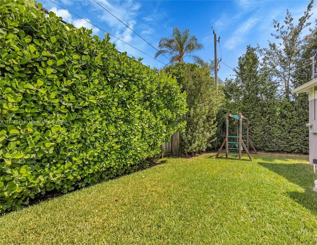 view of yard featuring a playground and fence