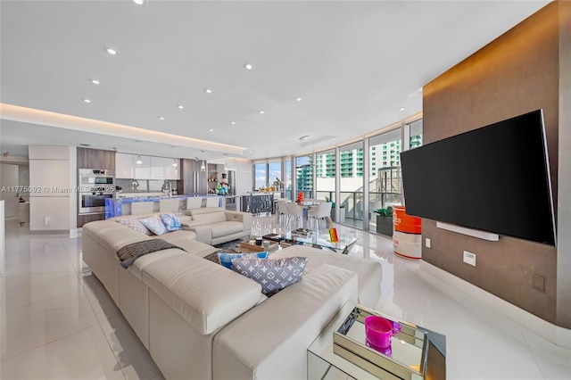 living room featuring light tile patterned floors, a wall of windows, and recessed lighting