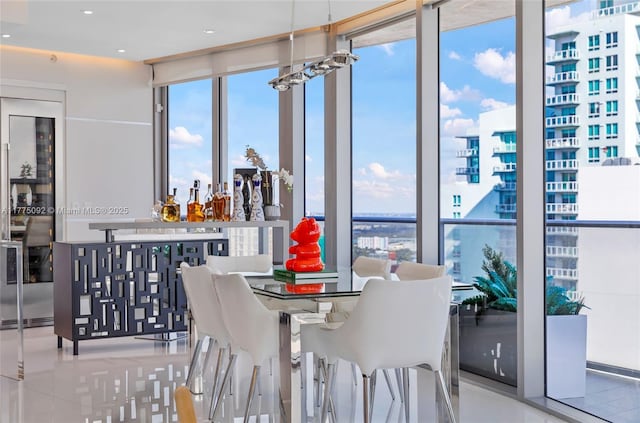 dining area with healthy amount of natural light, expansive windows, a dry bar, and recessed lighting