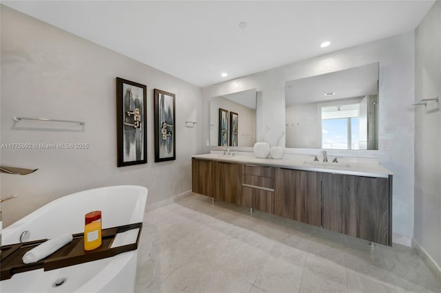 bathroom with a freestanding tub, double vanity, baseboards, and recessed lighting