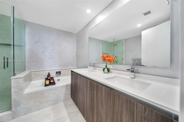 bathroom with a shower stall, a garden tub, double vanity, and recessed lighting