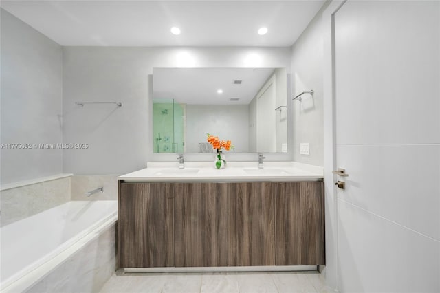 bathroom with double vanity, a garden tub, a shower, and recessed lighting