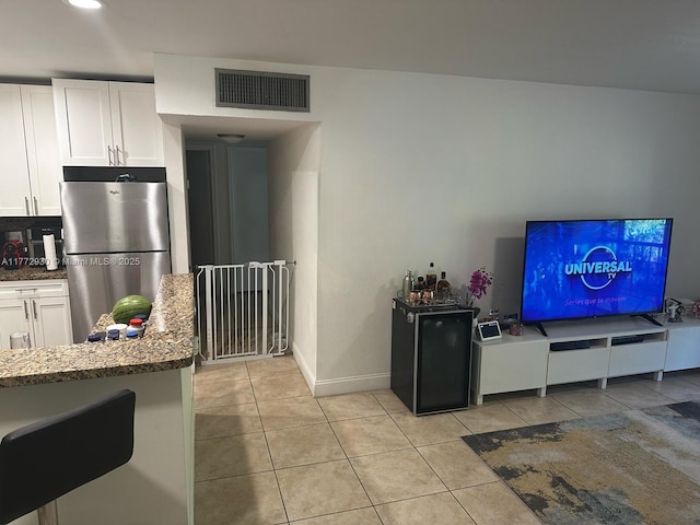 7951 SW 104th Unit 210D, Miami, FL 33156 - kitchen featuring freestanding refrigerator, white cabinetry, light tile patterned floors, dark stone counters, and baseboards