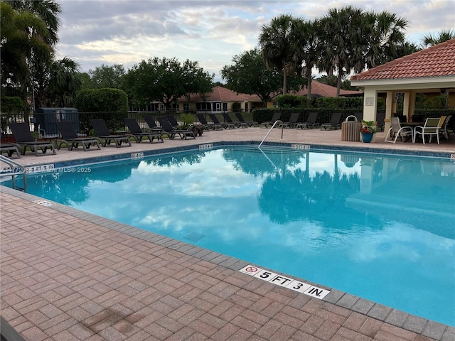 pool with fence and a patio
