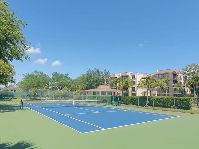view of tennis court featuring fence and community basketball court