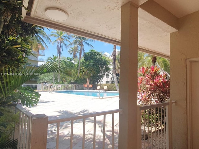 community pool featuring a patio area and fence