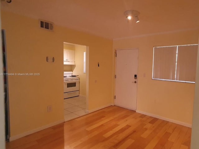 empty room with light wood finished floors and baseboards