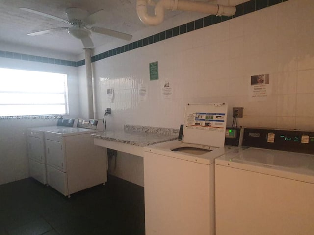 communal laundry room with washer and clothes dryer, a ceiling fan, and tile walls