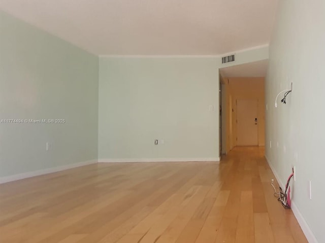 unfurnished room with light wood-type flooring and baseboards