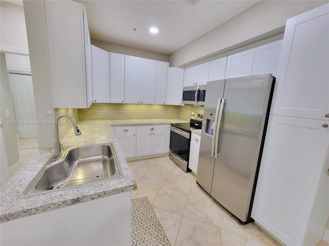 kitchen with recessed lighting, white cabinetry, backsplash, stainless steel appliances, and a sink
