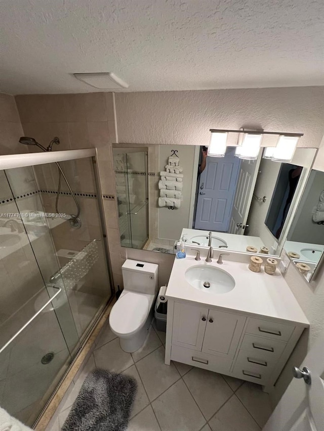75 Gulfstream Rd Unit 211B, Dania Beach, FL 33004 - full bath with a textured ceiling, tile patterned floors, a shower stall, vanity, and toilet