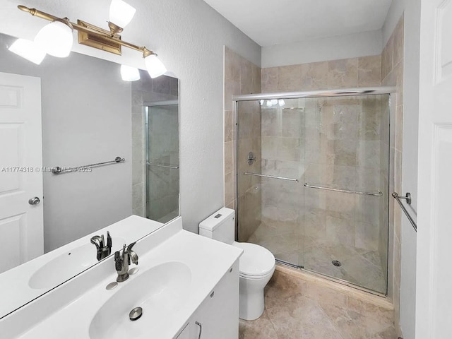 bathroom featuring a shower stall, vanity, and toilet