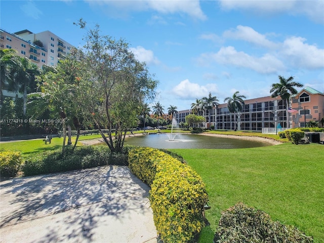 view of home's community with a water view and a yard
