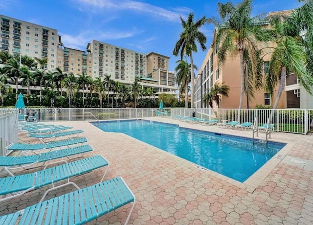 community pool featuring a patio and fence